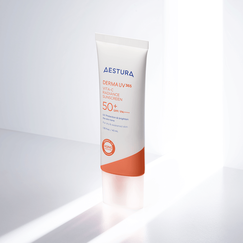 Aestura Derma UV 365 Vita-C Radiance Sunscreen in a white squeeze tube with a yellow cap and orange accents