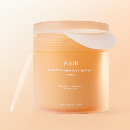 Abib Glutathiosome Dark Spot Pad Vita Touch in a clear jar with yellow toner pads and a white screw cap
