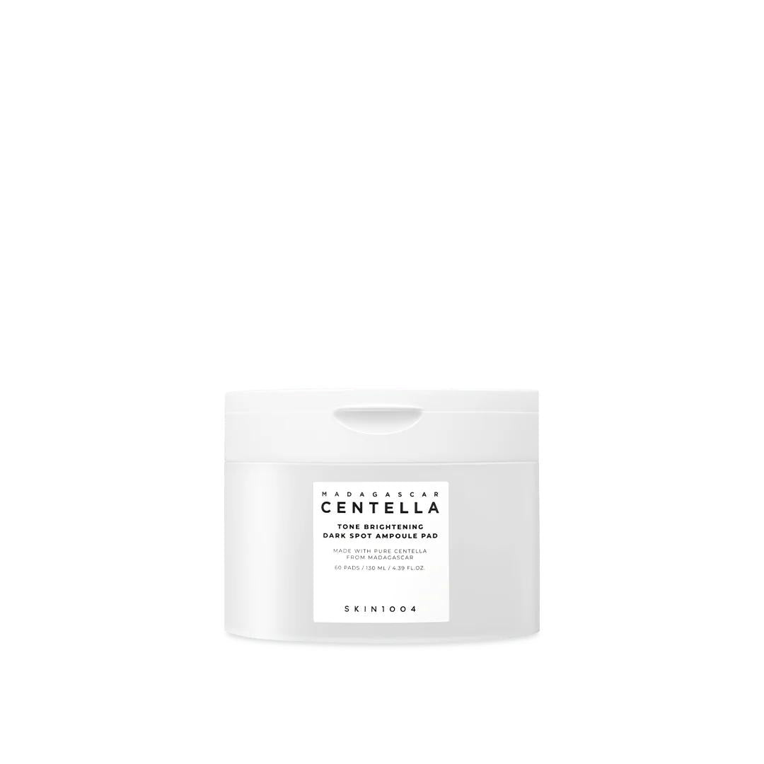 SKIN1004 Madagascar Centella Tone Brightening Dark Spot Ampoule Pad in a clear jar with white round cotton pads inside